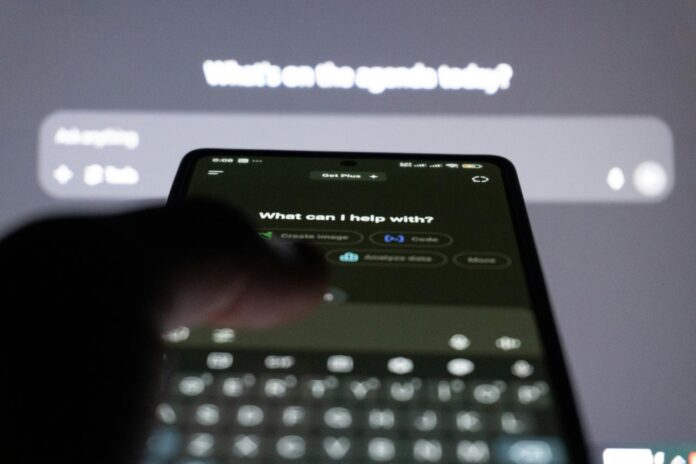 Orang yang mengetik di smartphone dengan chatbot ai di layar.
